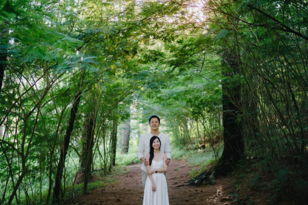 Romantic morning walk of a couple through the quiet Kintamani pine forest after sunrise
